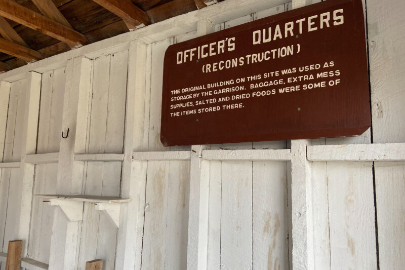 an explanatory sign for the officers' quarters is hung on a white wooden wall