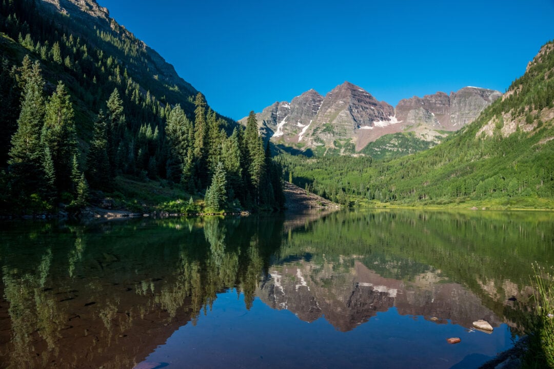 mountain peaks are reflected in a lake