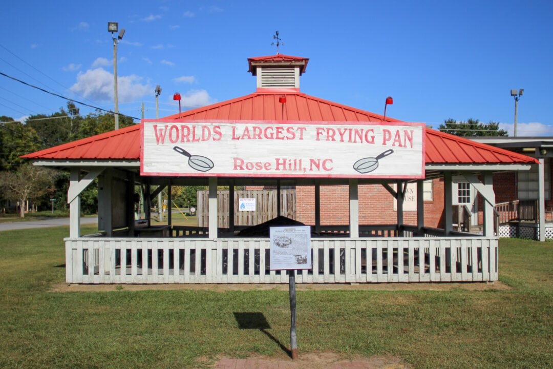 a red and white gazebo that houses the world's largest frying pan in rose hill, nc