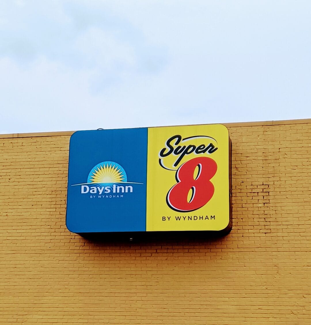 a sign for a days inn and super 8 on a yellow brick building