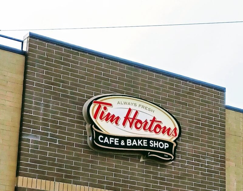 a sign for Tim Hortons on a brown brick building