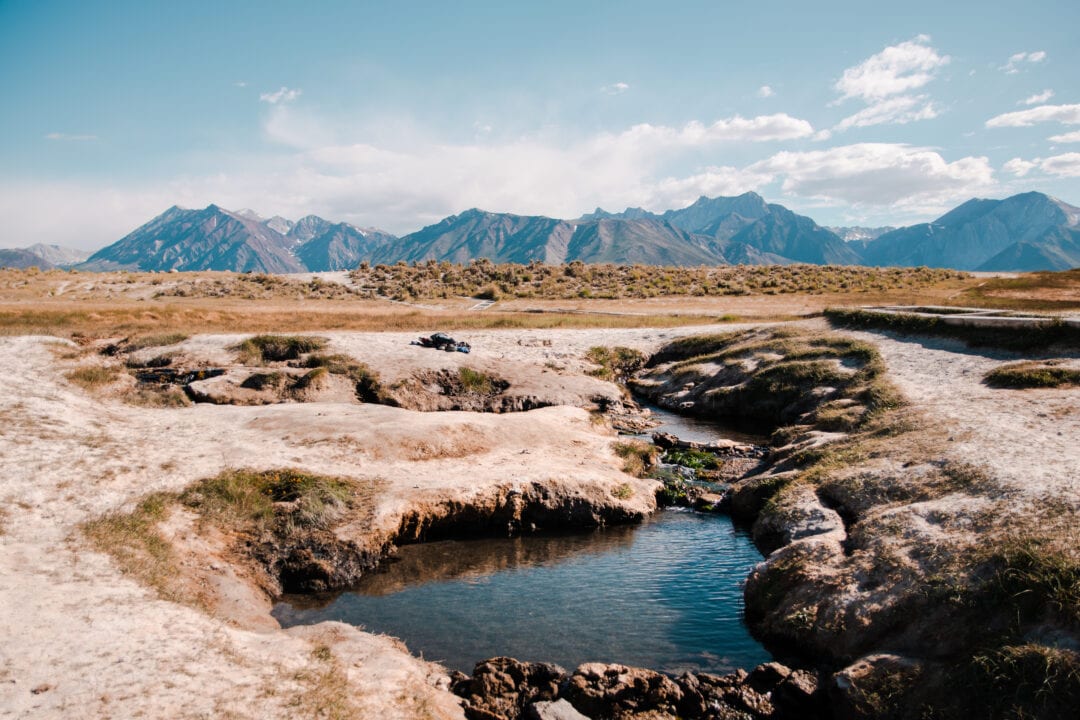 hot springs in a desert landscape with mountains in the background