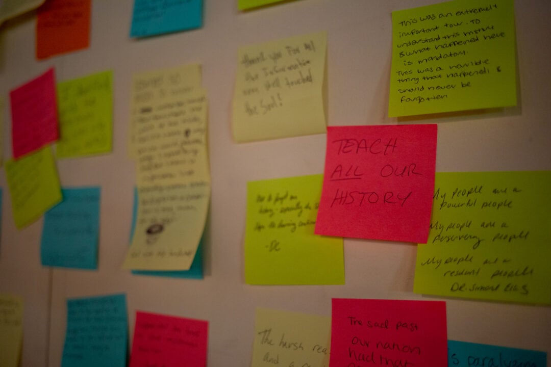 colorful post it notes with messages stuck to a white wall