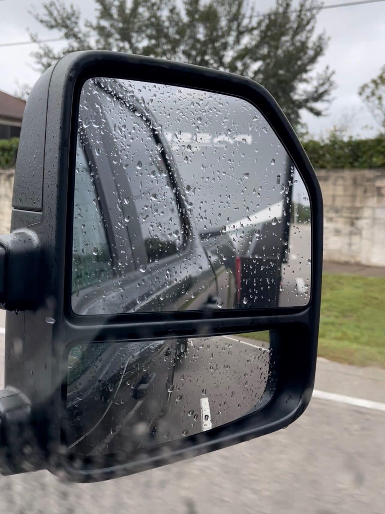 Close-up of a truck side mirror splashed with raindrops