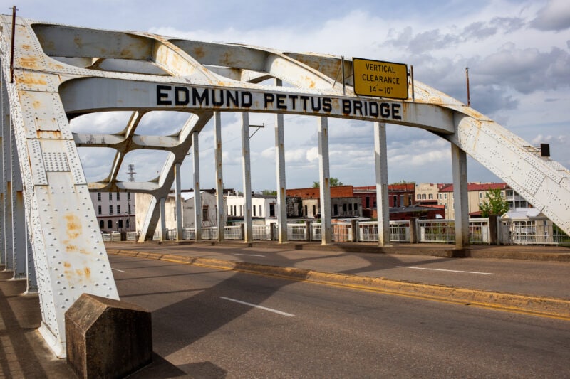 the edmund pettus bridge, a gray steel bridge over a road