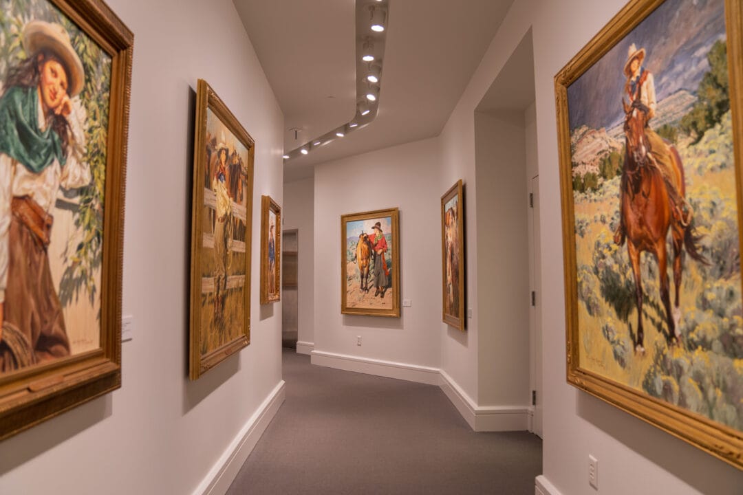Artwork featuring cowgirls on display in a museum