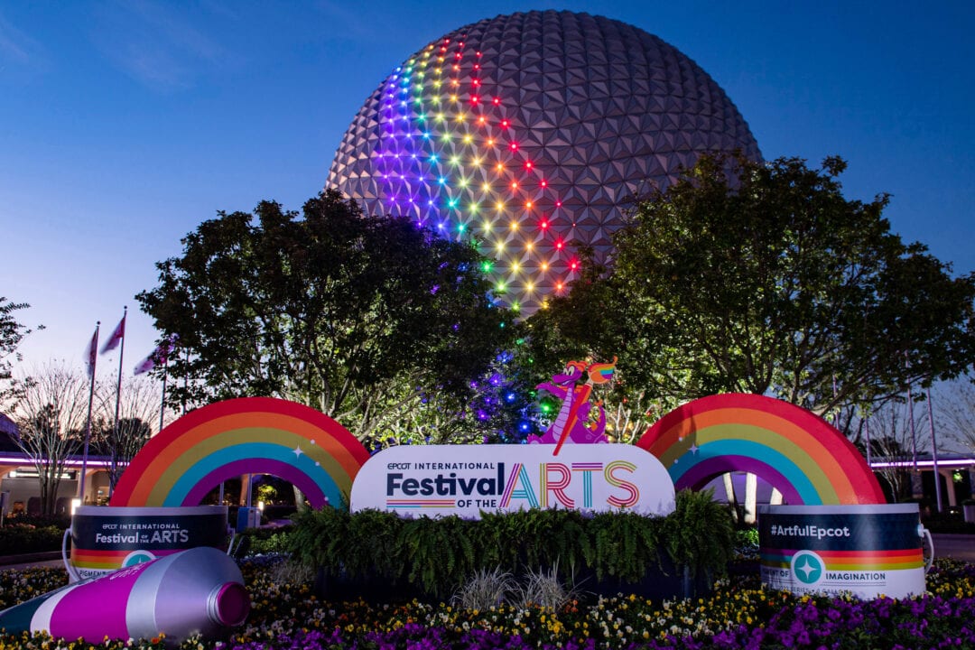 The large sphere of EPCOT lit up in rainbow colors for the festival of the arts in 2022