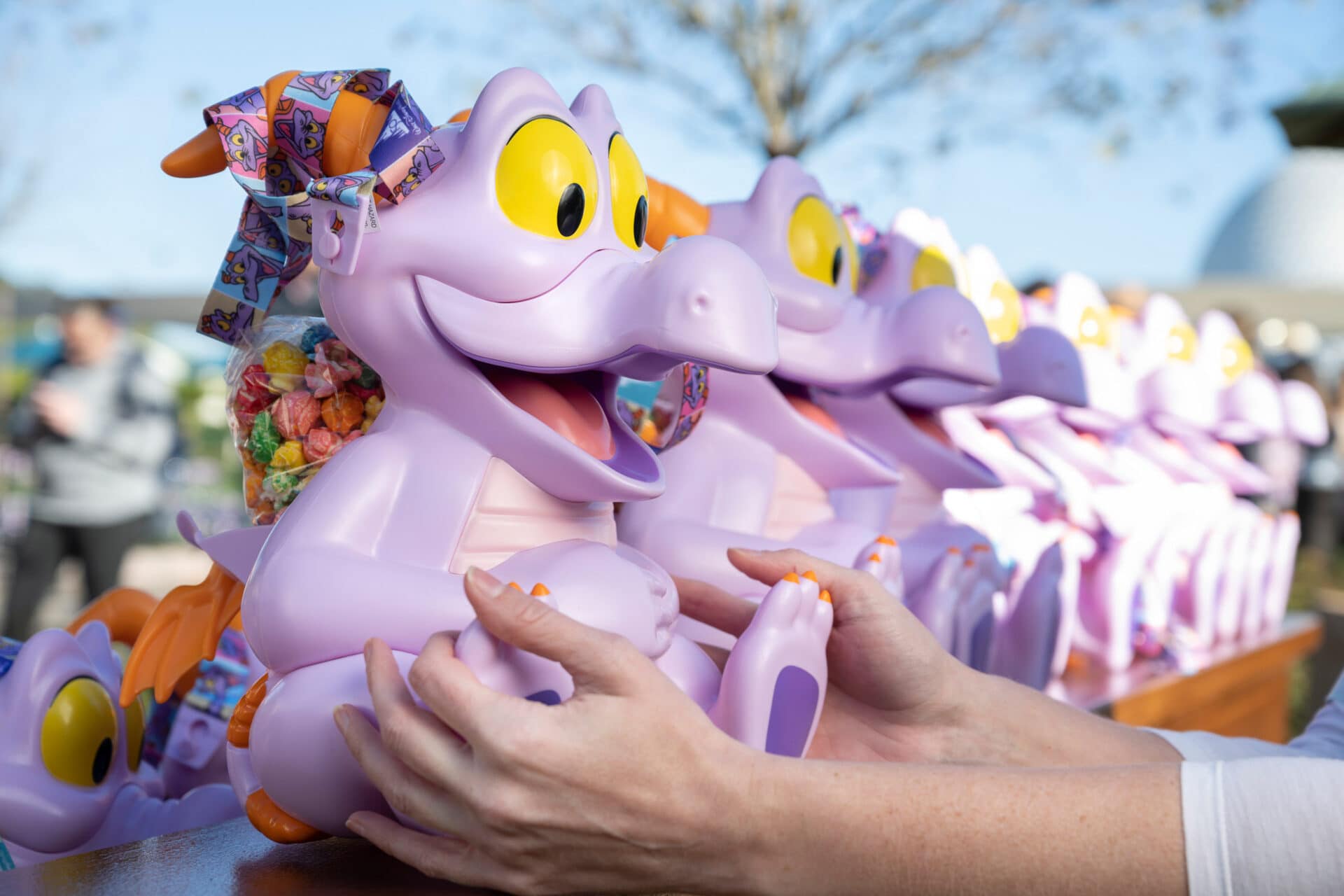 a line of popcorn buckets shaped like a purple dragon