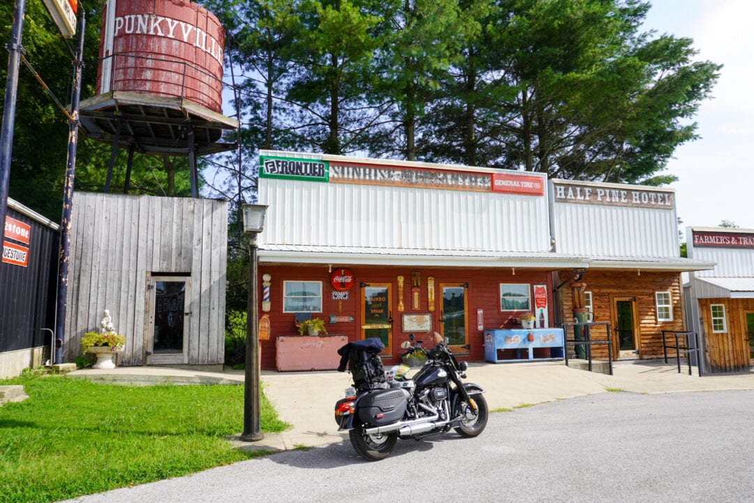 A black motorcycle parked in front of an Old West-style retro town