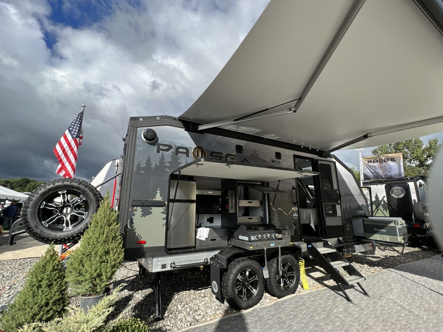 A rugged off-grid trailer with an outdoor kitchen and open awning