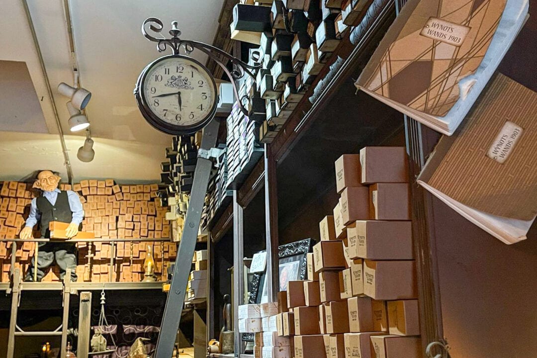 a wand shop with stacks of thin cardboard boxes on shelves and a clock