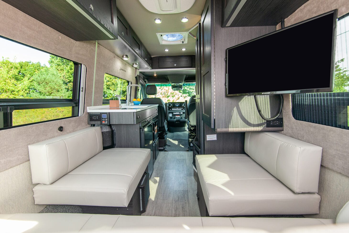 An interior view of a Class B motorhome showcases the RV's light and bright interior decor.