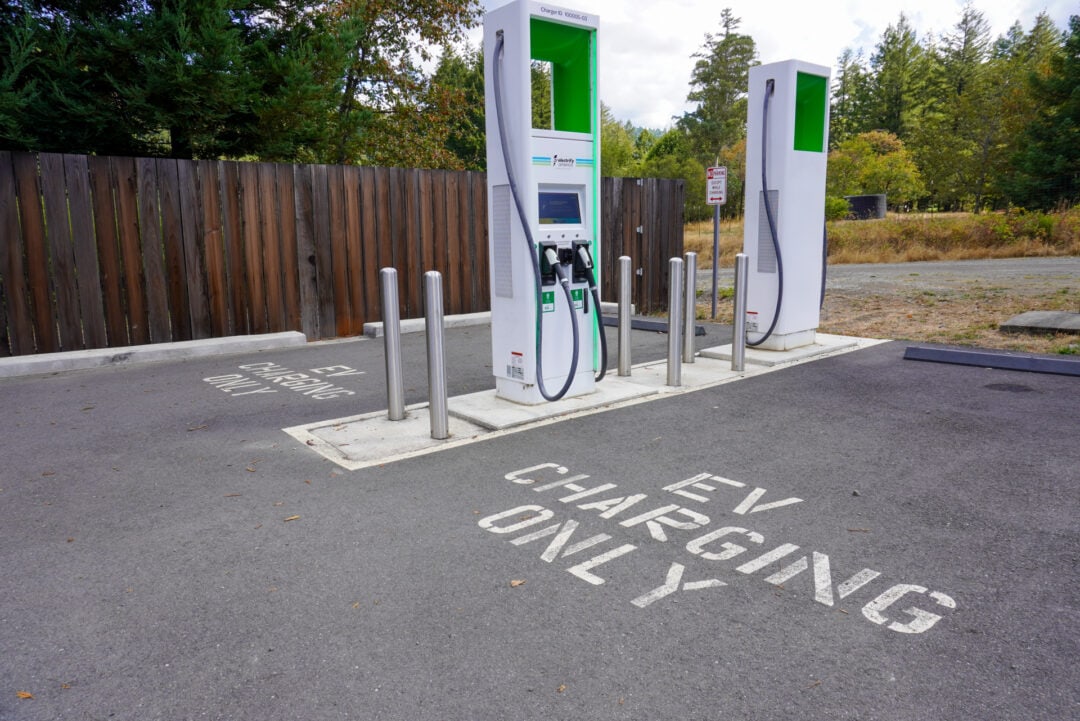 Two EV charging stations next to two  designated EV charging parking spots