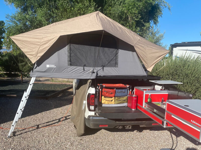 A truck bed serves as the home base for a tent.
