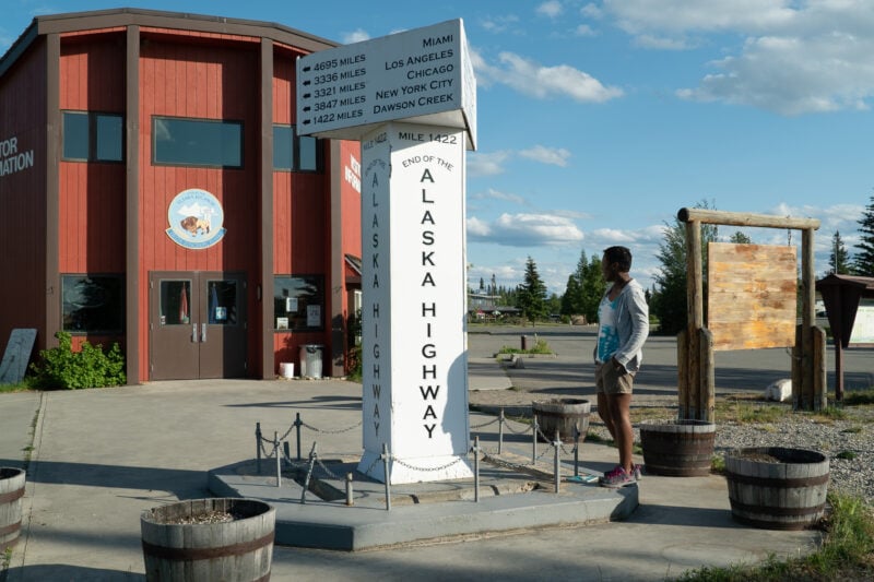 A large sign for the Alaska Highway notes the distance to famous U.S. locales.