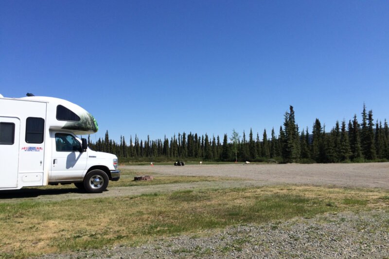 A rented Class C motorhome sits alone in a campground.