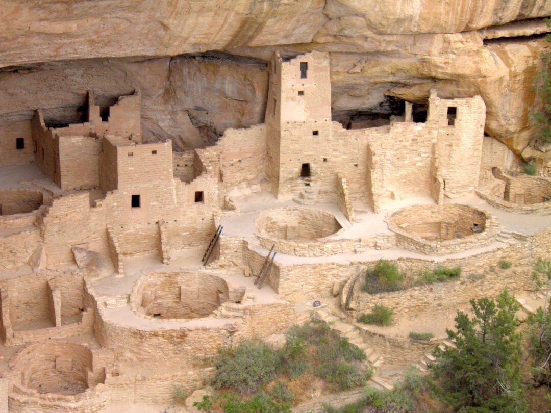 Rough dwellings are carved into the side of a cliff.