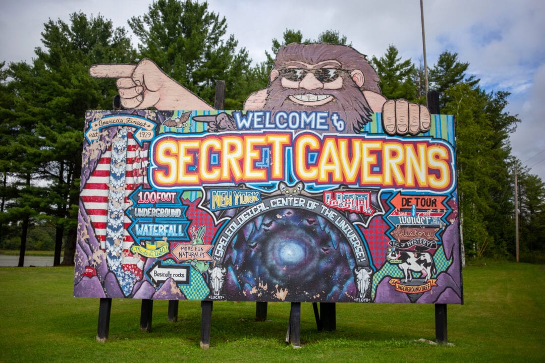 an intricately colorful handpainted billboard for secret caverns