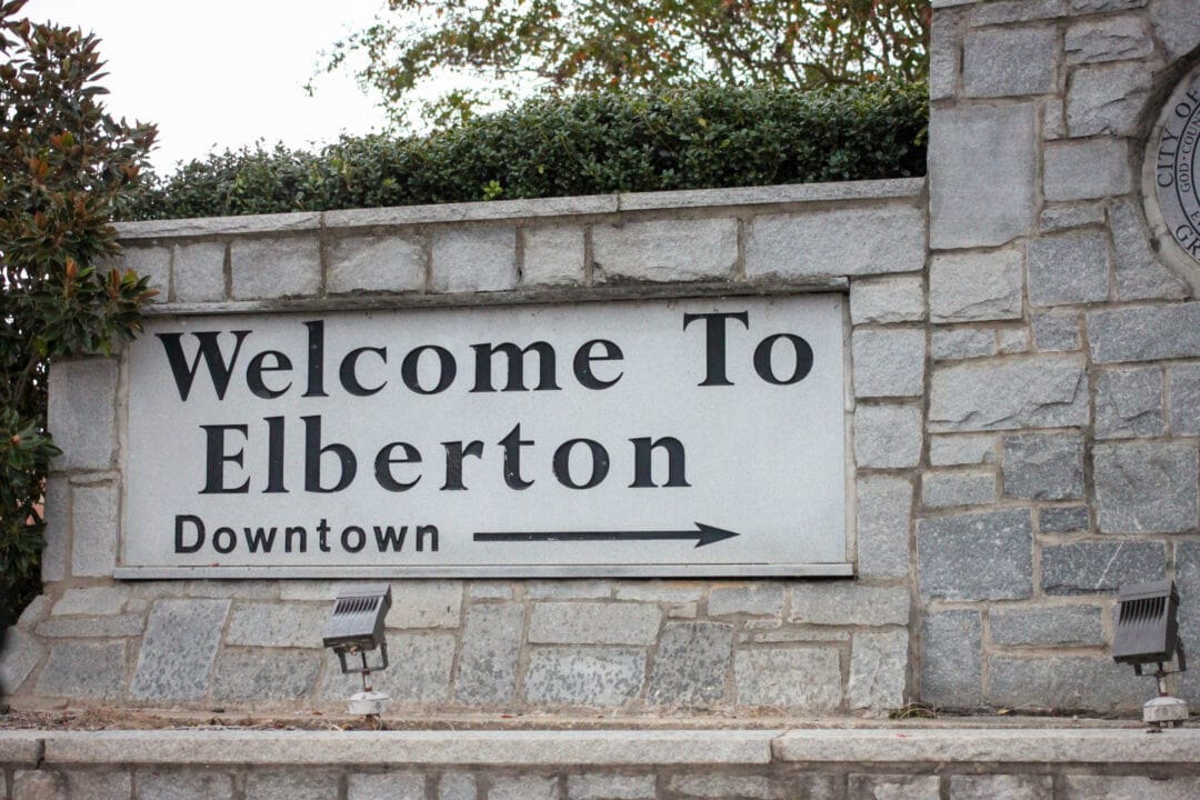 A white marble sign reads "Welcome to Elberton."