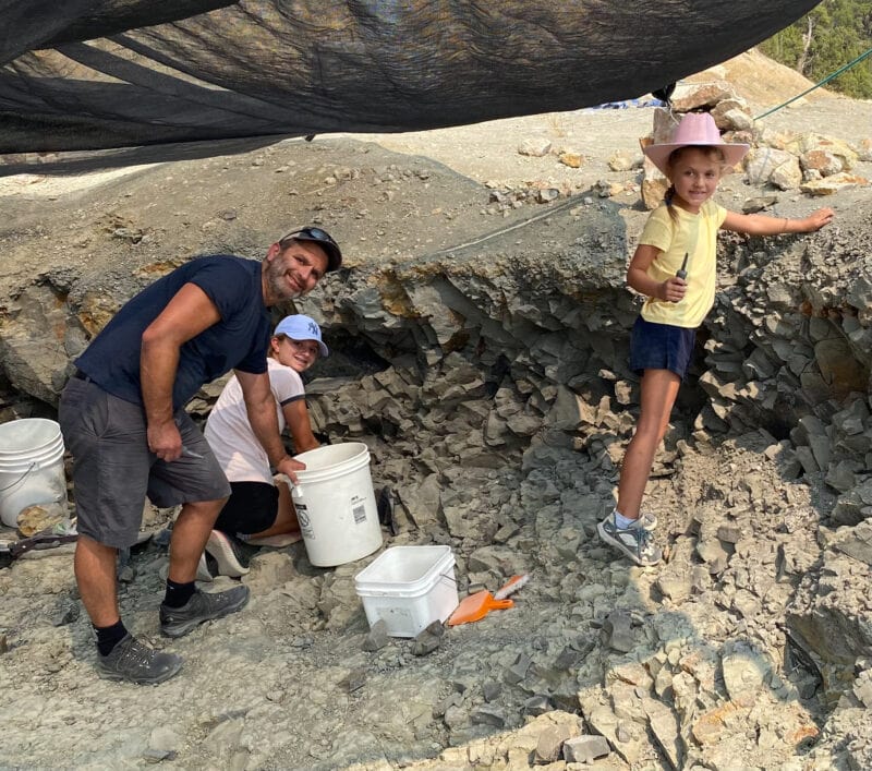 A family digs through the dirt in search of dinosaur fossils.