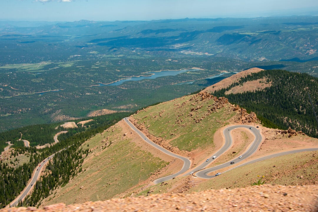 The view from atop a mountain showcases an extremely windy road filled with sharp turns.