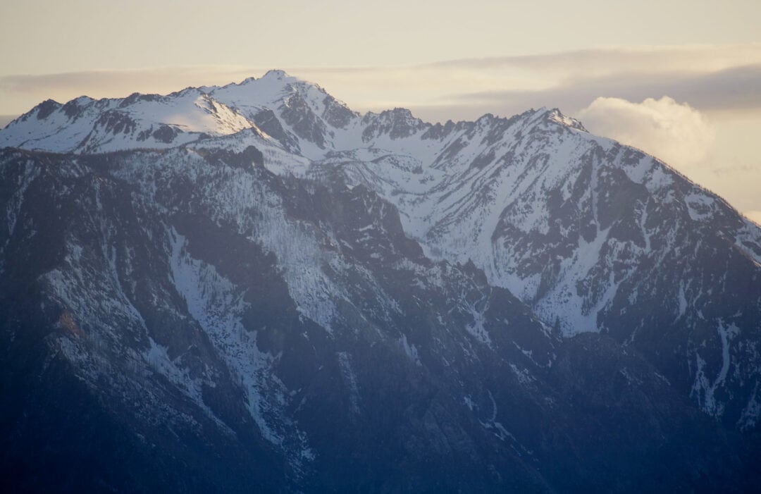 Snow-covered mountain peaks rise dramatically into the sky.
