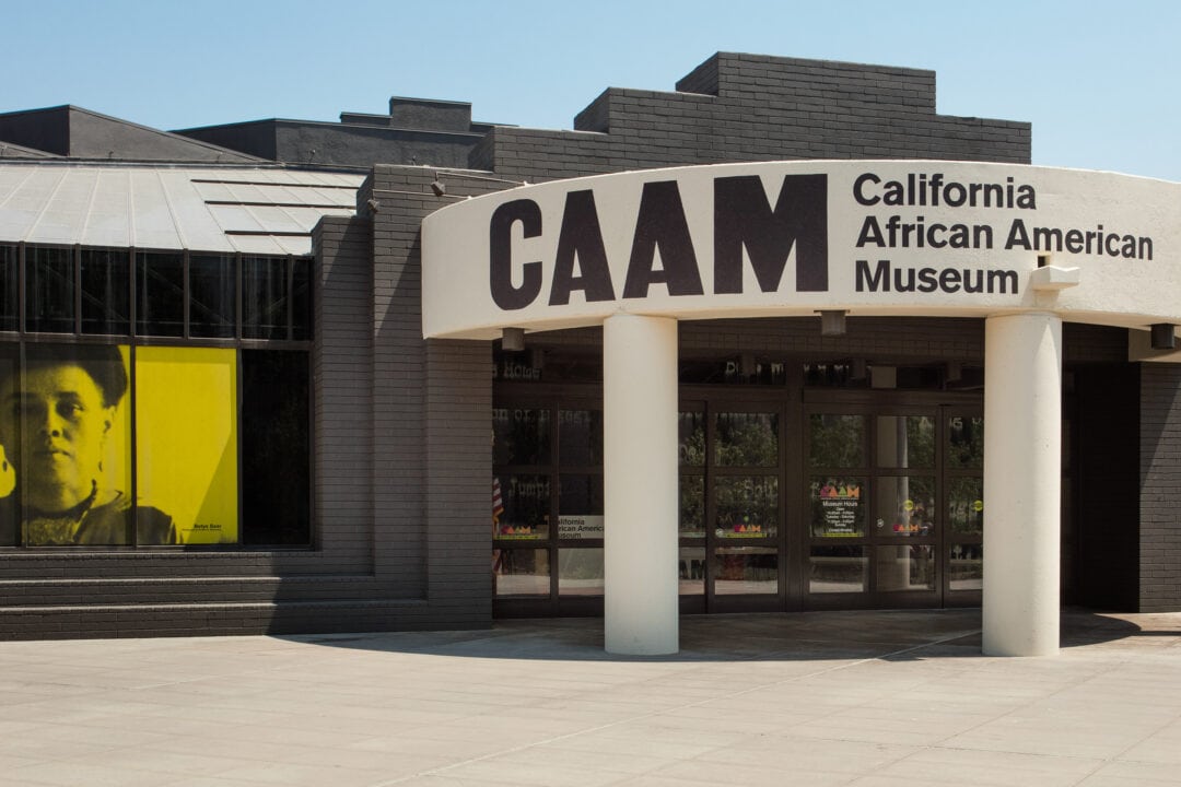 The entrance California African American Museum, a grey brick building with a curved concrete entryway