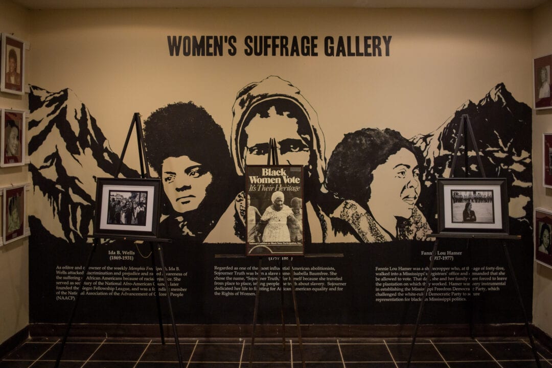 a women's suffrage gallery featuring illustrations of suffragettes and information