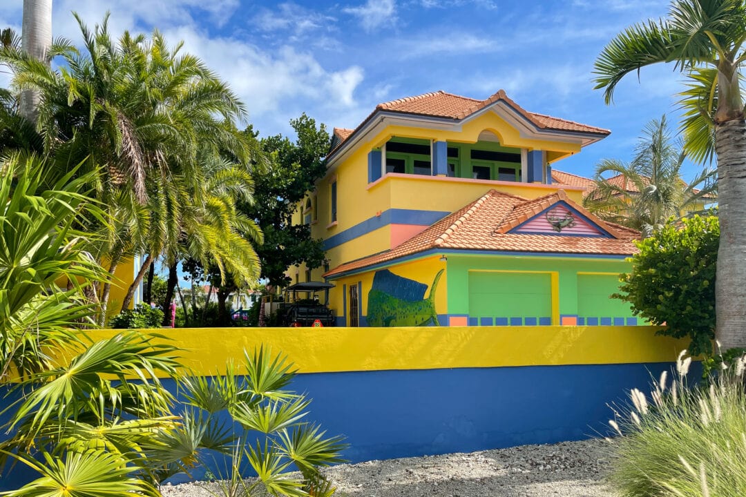 A brightly colored house is painted in shades of peach, green. blue, and yellow.
