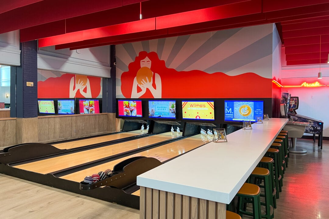 A bowling alley is decorated with bright colors and charming murals.