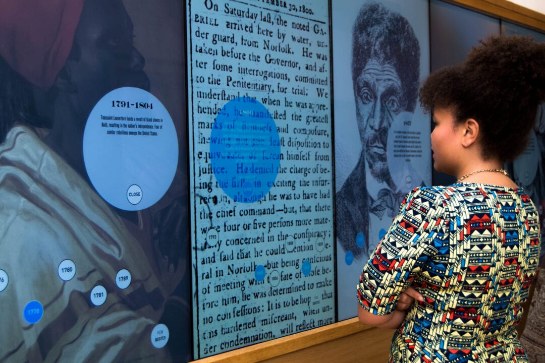 A person examines a historical exhibit at the Black History Museum and Cultural Center of Virginia.