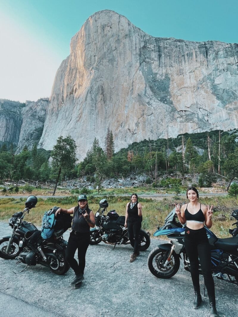 Three motorcyclists park their rides in front of a large rock formation at Yosemite National Park