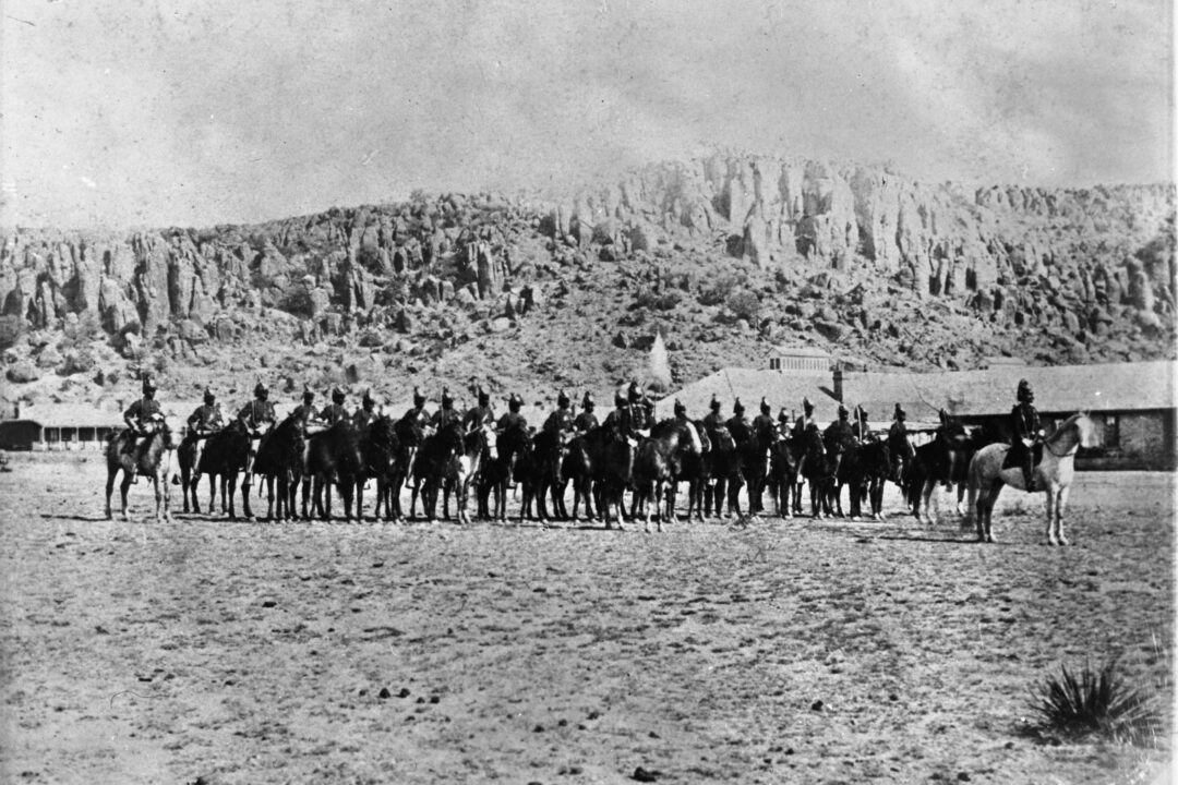 A black and white photo of soldiers on horseback.
