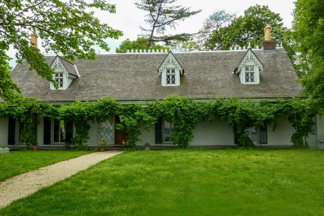 The Alice Austen House is an unassuming white building covered in greenery on the exterior