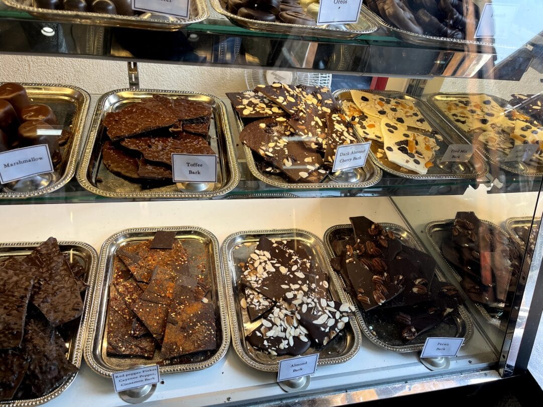 A display of various chocolate items inside a glass compartment