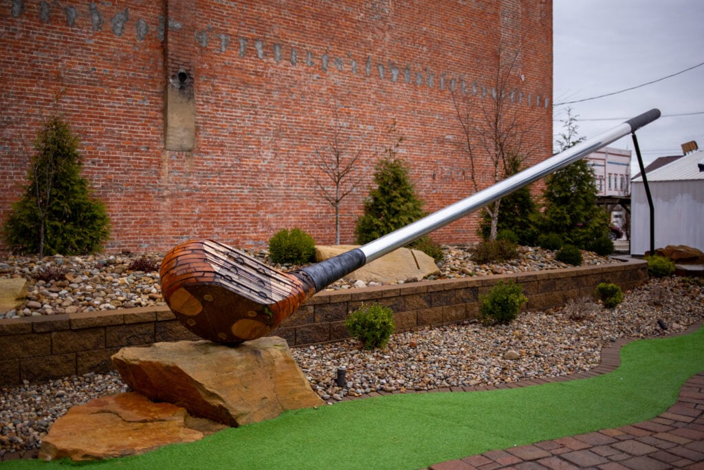 an oversized golf driver sculpture with a wooden head
