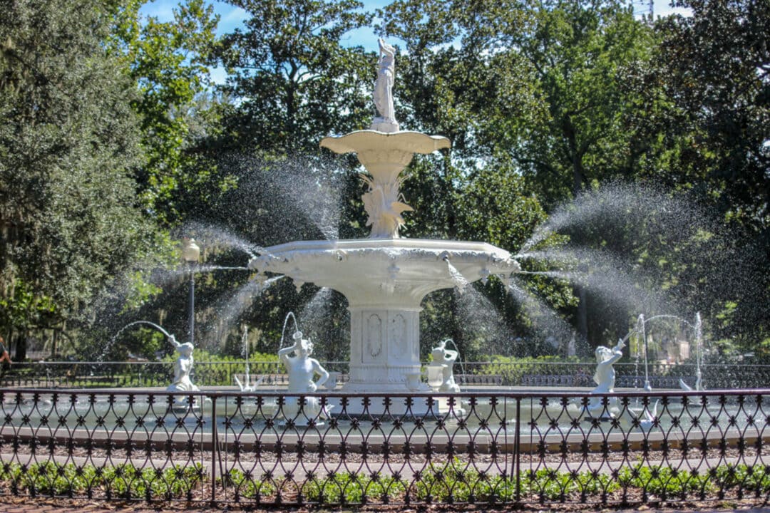 a white fountain in the middle of a park