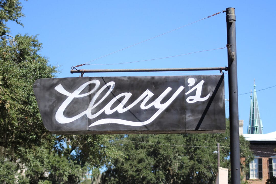 a black enamel sign with white script that says "clary's"