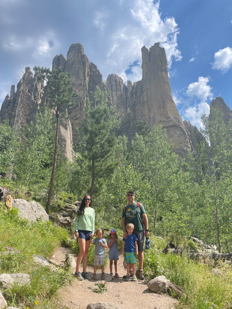 A family poses in front of spires at Custer State Park in South Dakota