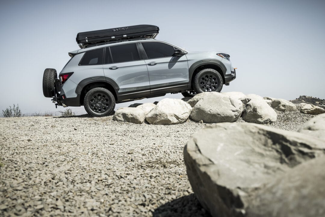A concept vehicle, the 2023 Honda Passport TrailSport, crosses over large boulders.