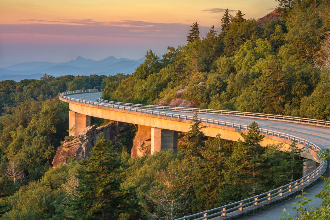 A winding stretch of the Blue Ridge Parkway curves along the side of a mountain
