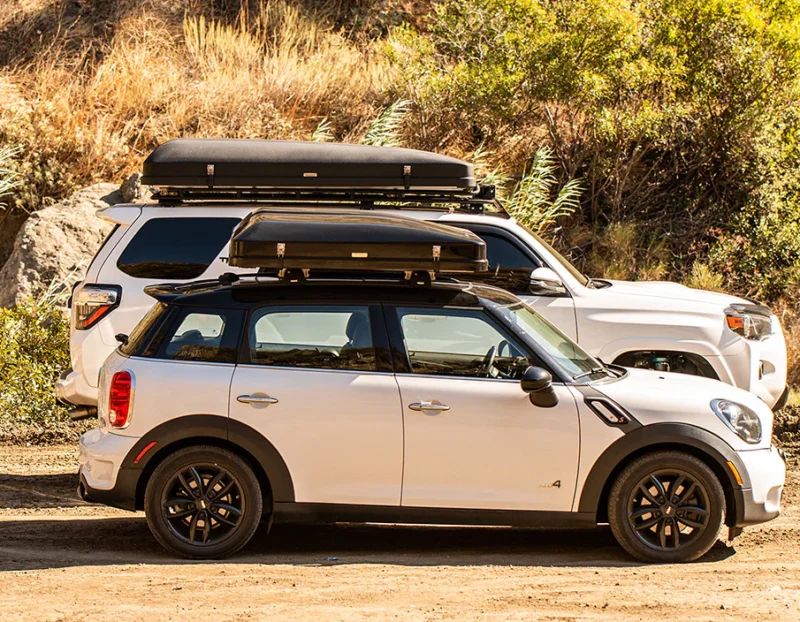 White Mini Cooper parked next to an SUV with closed rooftop tents on both vehicles