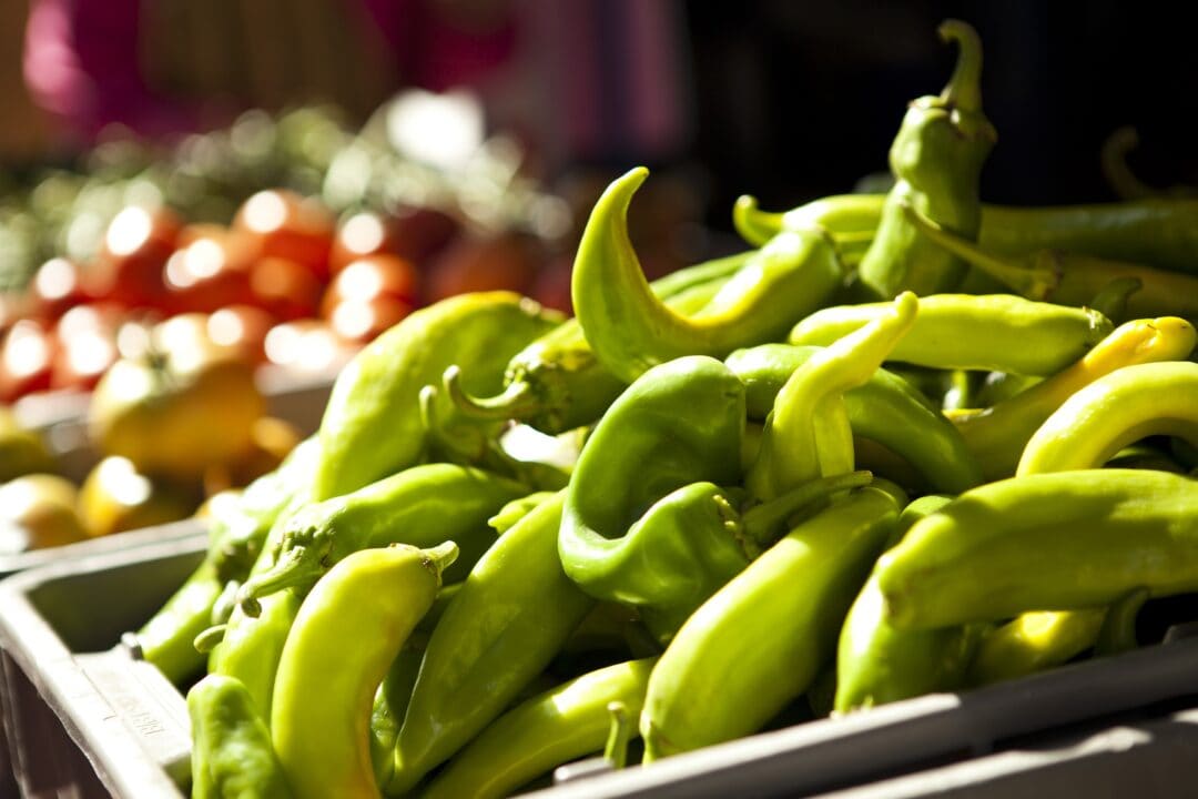 Green chilis are stacked up at a market