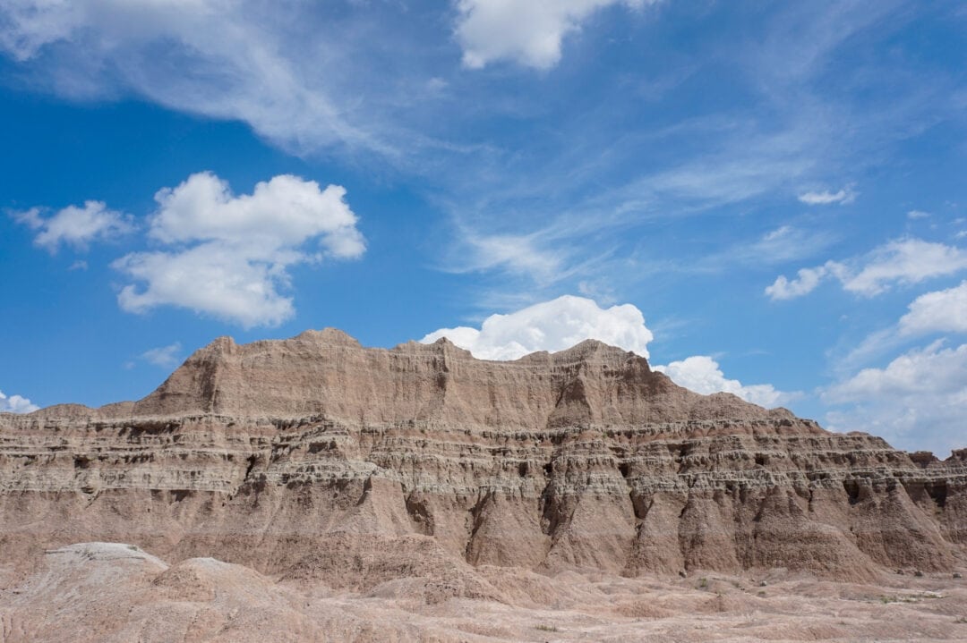 Multicolored sandstone cliffs against a blue sky with a few clouds