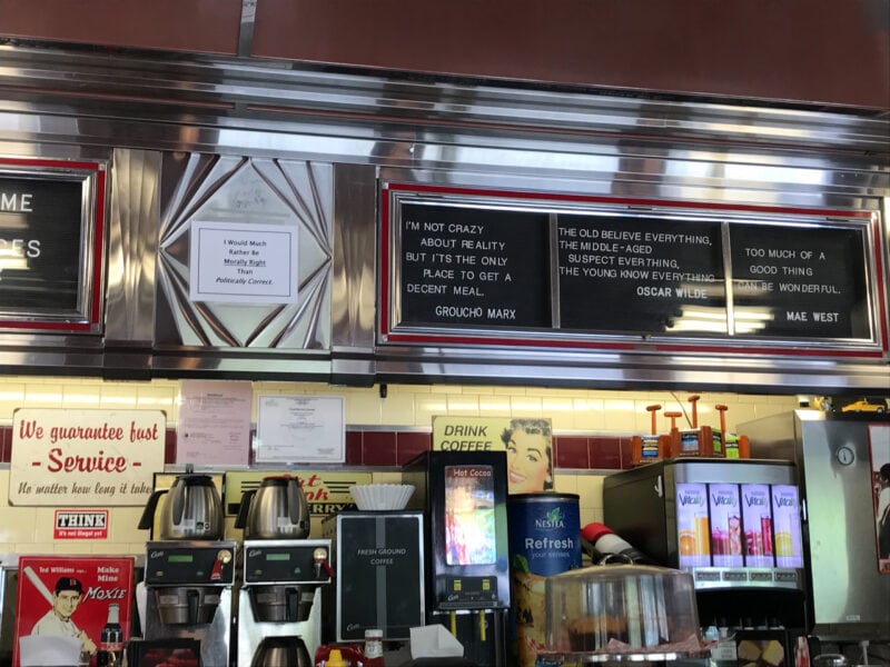 A retro style diner features a large menu board