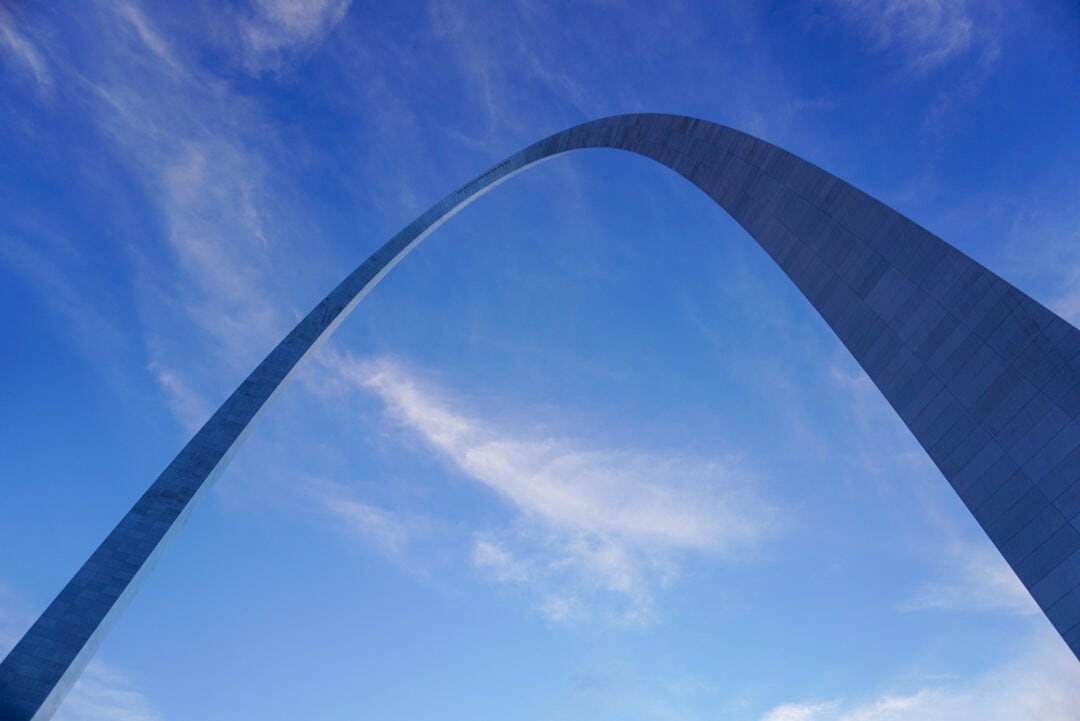 A massive arch against a blue sky, as seen from below