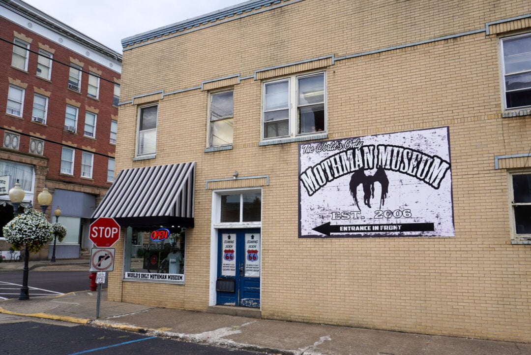 A brick building features a large sign that reads "Mothman Museum"