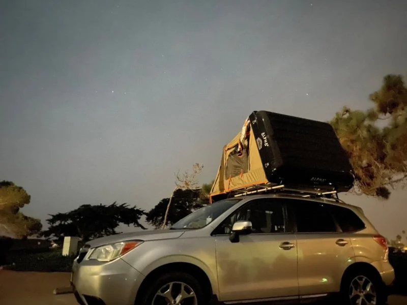Small SUV with an open rooftop tent 