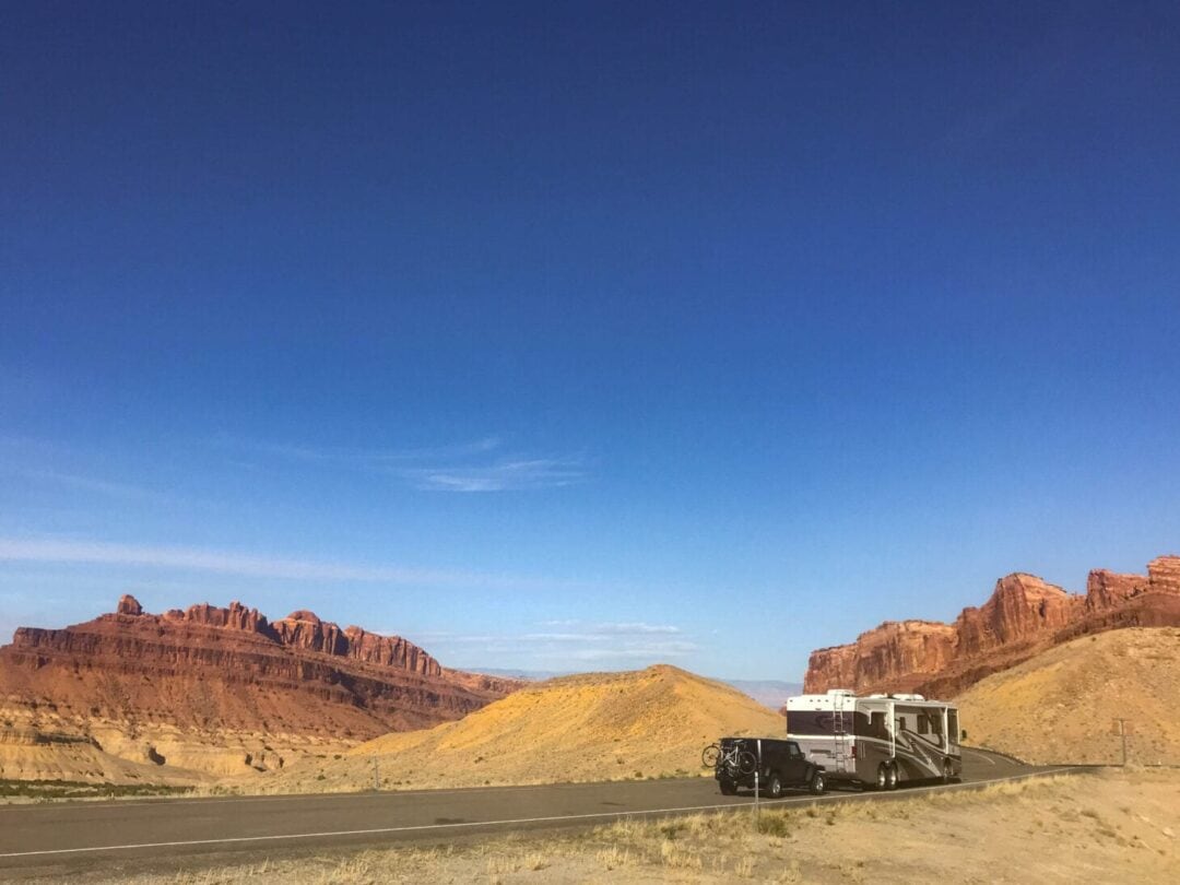 Motorhome towing a jeep along desert road