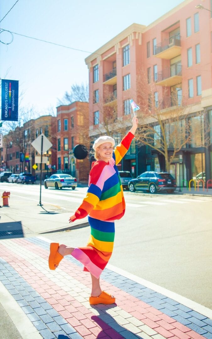 Courtney Vondran strikes a pose on a city street while decked out in rainbow clothing
